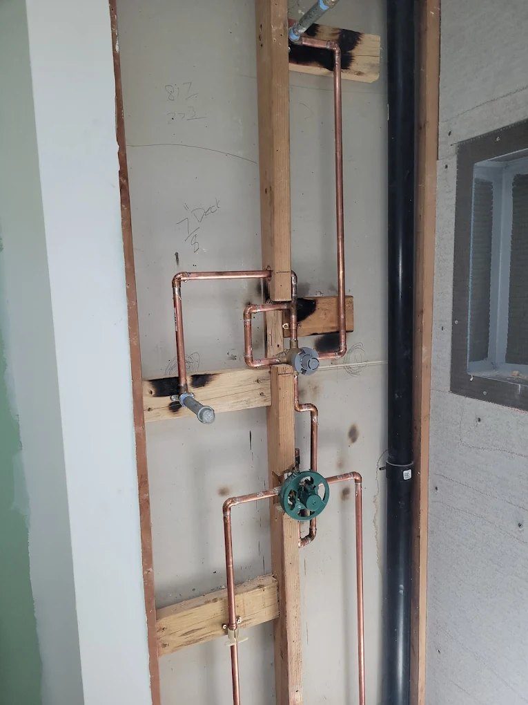 Copper plumbing pipes and valve installed on interior wall framing